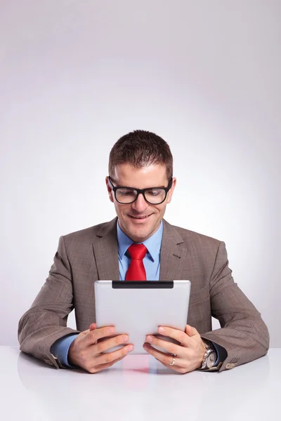 Junger Geschäftsmann liest vom Tablet — Stockfoto