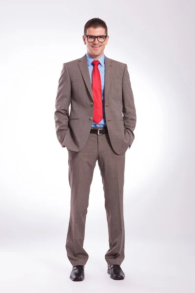 Young business man standing with both hands in pockets — Stock Photo, Image