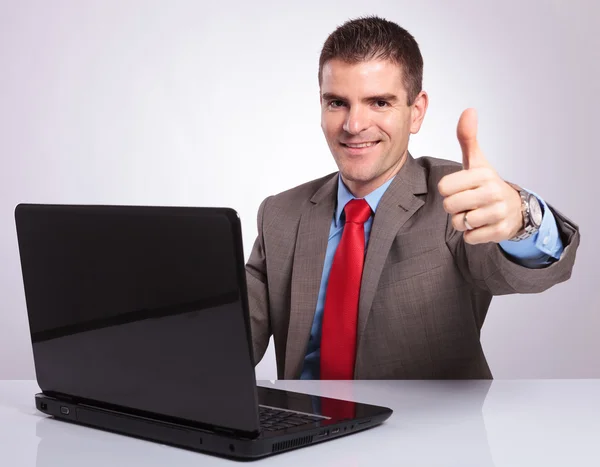 Fiatal üzletember felbukkan hüvelykujj mögött laptop — Stock Fotó