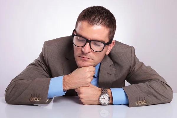 Young business man sleeps on his fists at office — Stock Photo, Image