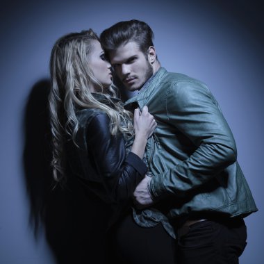 fashion couple in leather jackets pulling each other closer clipart