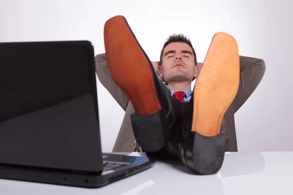 Joven hombre de negocios duerme en el trabajo con los pies en el escritorio —  Fotos de Stock