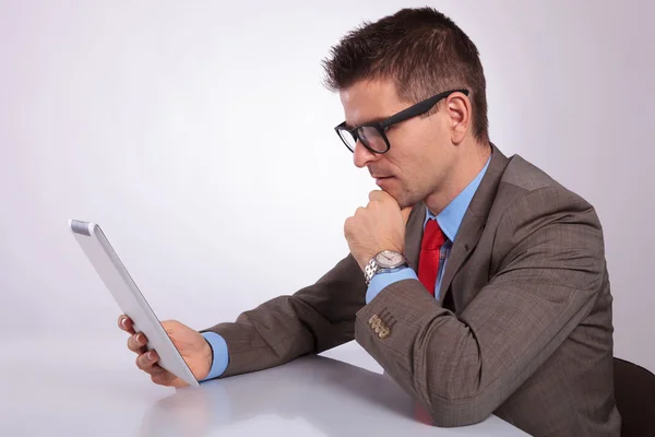 Lato del giovane uomo d'affari guardando pensieroso al suo tablet — Foto Stock