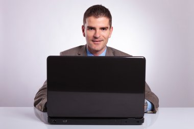 genç iş adamı gülümseyerek arkasından laptop