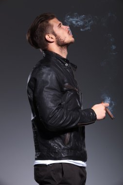 Sigara ve duman üfleme deri ceketli adamı