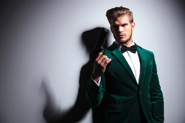 Hombre en traje de terciopelo verde elegante sosteniendo una pistola grande —  Fotos de Stock