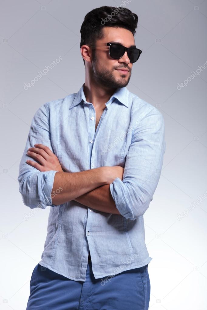 casual man with crossed hands looks away