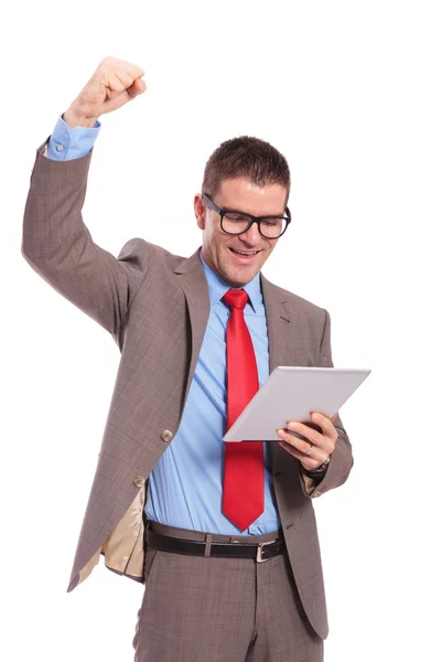 Young business man holds tablet and cheering — Stock Photo, Image
