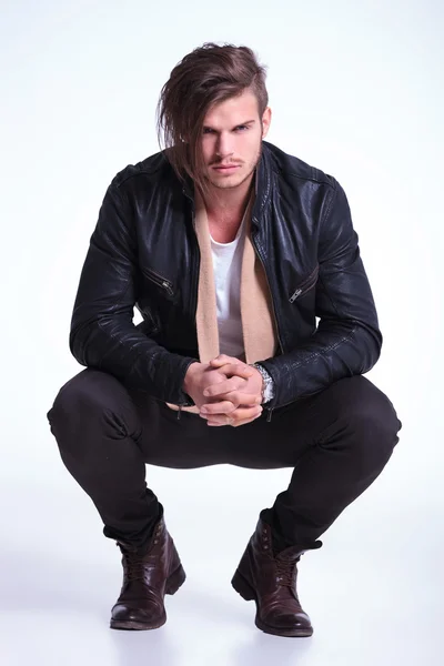 Serious man in leather jacket standing couched — Stock Photo, Image