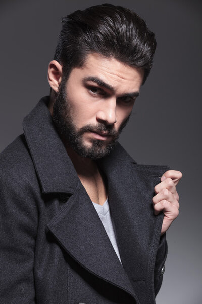 модный мужчина с длинной бородой, держащий воротник
