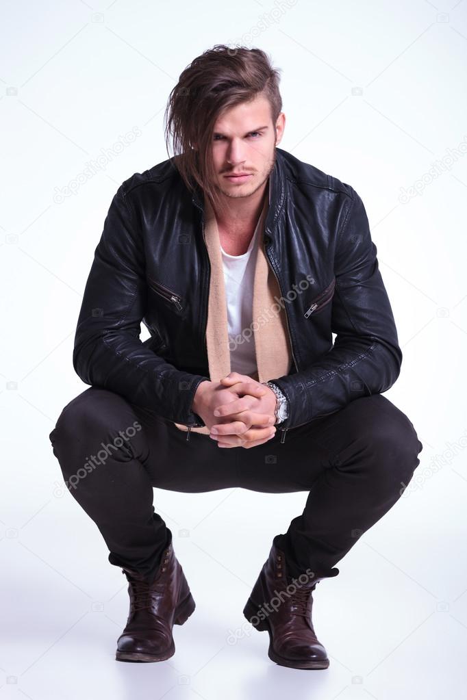 serious man in leather jacket standing couched