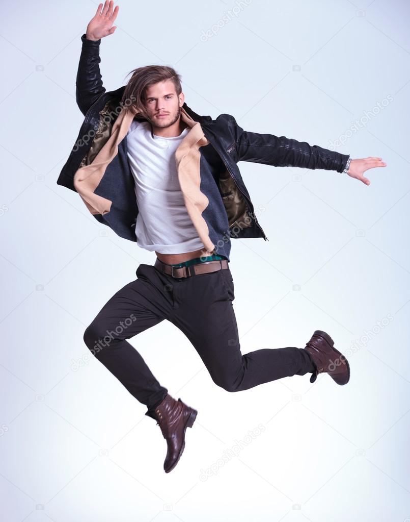 young man in casual clothes is making a high jump