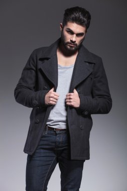 fashion bearded man holding his long coat