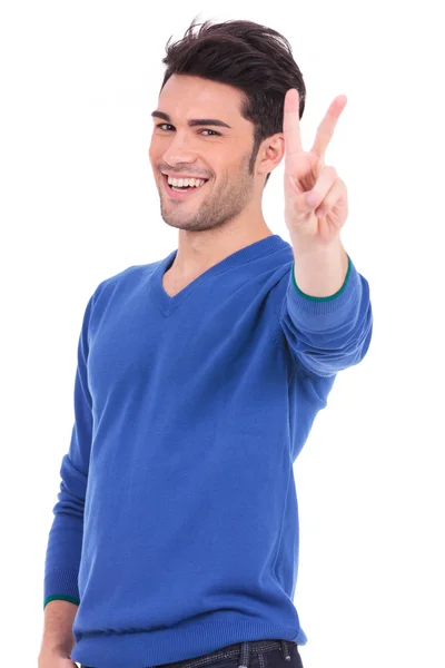 Joven sonriente haciendo la señal de victoria —  Fotos de Stock