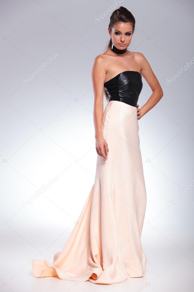 side view of a young sexy woman in a long evening dress
