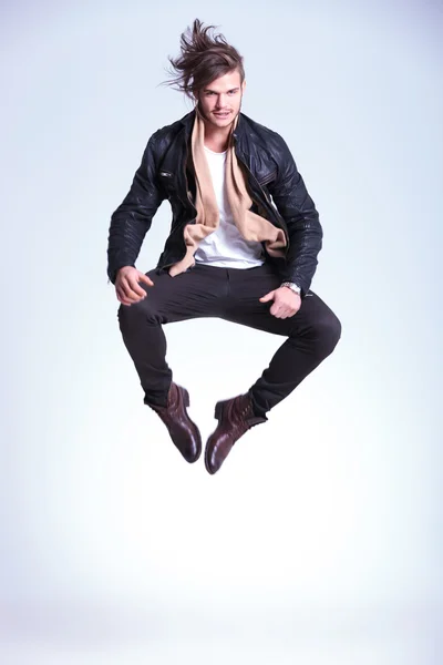 Happy young man in leather jacket jumps — Stock Photo, Image