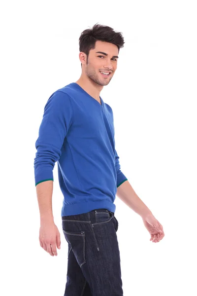Vista lateral de um jovem homem sorridente andando — Fotografia de Stock