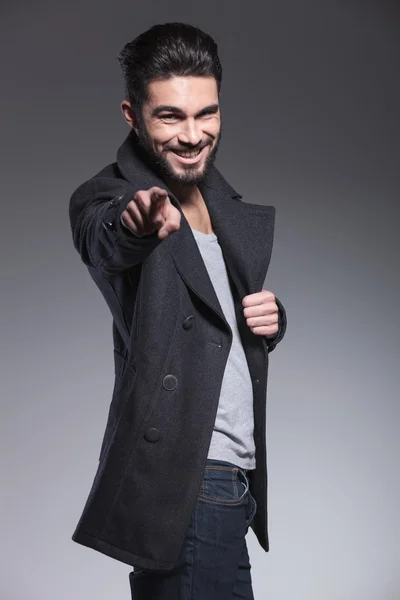 Jovem barbudo homem está sorrindo e apontando o dedo — Fotografia de Stock