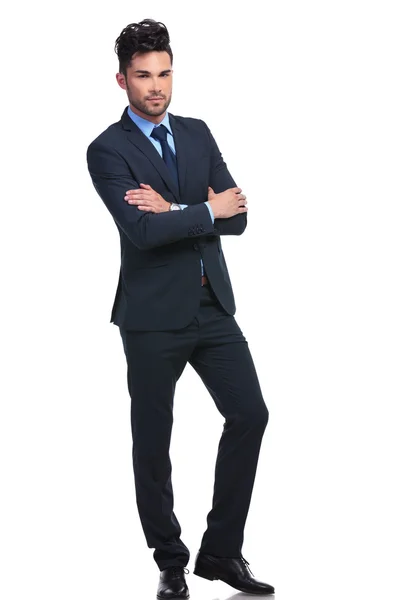 Confiante jovem homem de negócios de pé com as mãos cruzadas — Fotografia de Stock