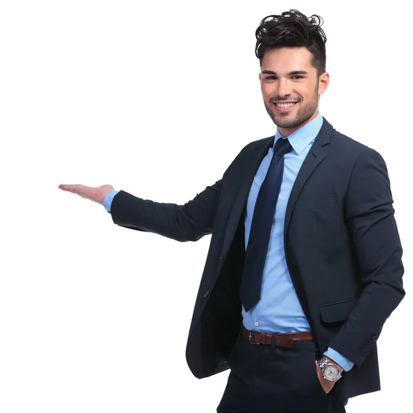 Retrato de un hombre sonriente presentando algo — Foto de Stock