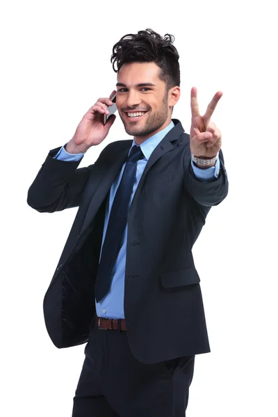 Homem de negócios no telefone fazendo o sinal de vitória — Fotografia de Stock