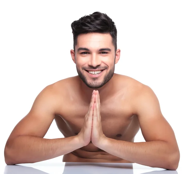 Młody człowiek uśmiechający się modli — Zdjęcie stockowe