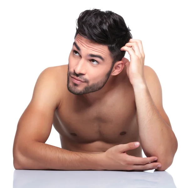 Beauty man scratching his head and looking up to his side — Stock Photo, Image