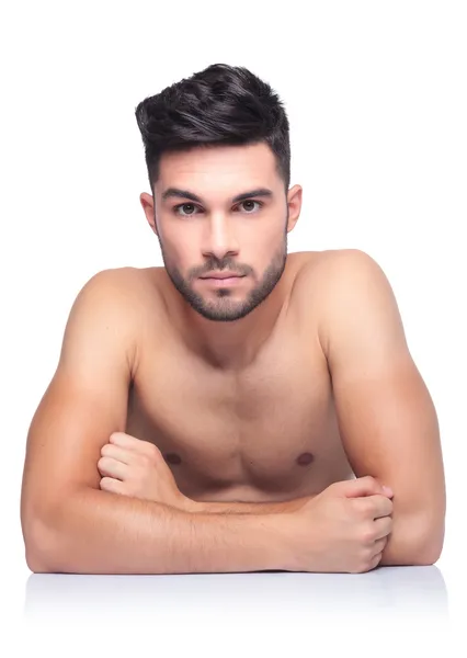 Jeune homme de beauté nu assis à une table — Photo