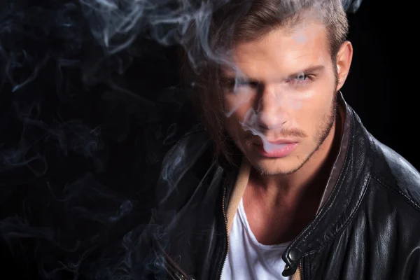 Man in leather jacket covered in smoke — Stock Photo, Image