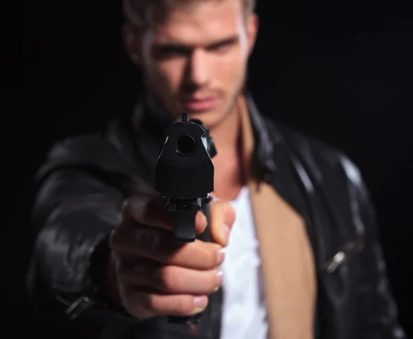 Young assasin pointing his gun to the camera — Stock Photo, Image