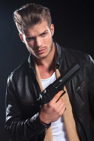 Sicario en ropa de cuero sosteniendo una gran pistola en su mano — Foto de Stock