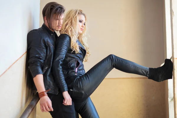 Couple standing against a wall and looking out the window — Stock Photo, Image