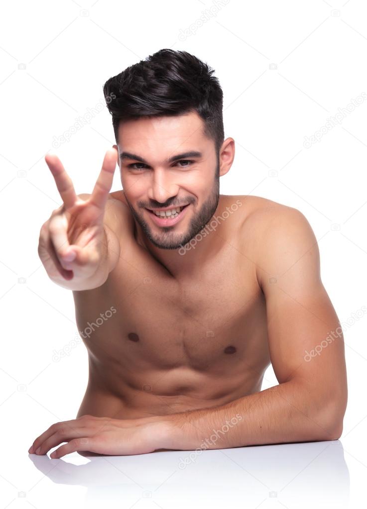 naked young man making the victory sign