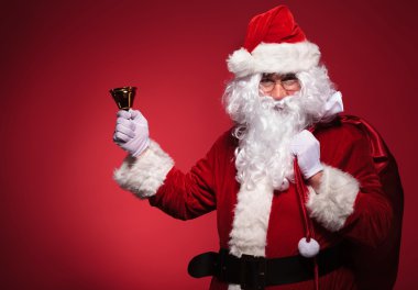 Santa claus üzem táska, a váll és a jobb kezében egy harang
