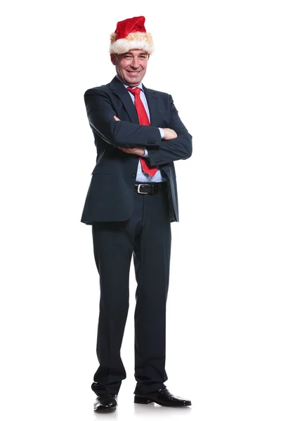 Business man wearing santa hat and standing with hands crossed — Stock Photo, Image