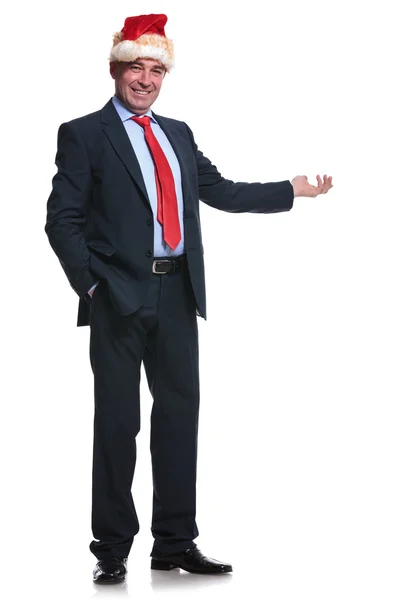 Full body picture of a mature business man santa presenting — Stock Photo, Image