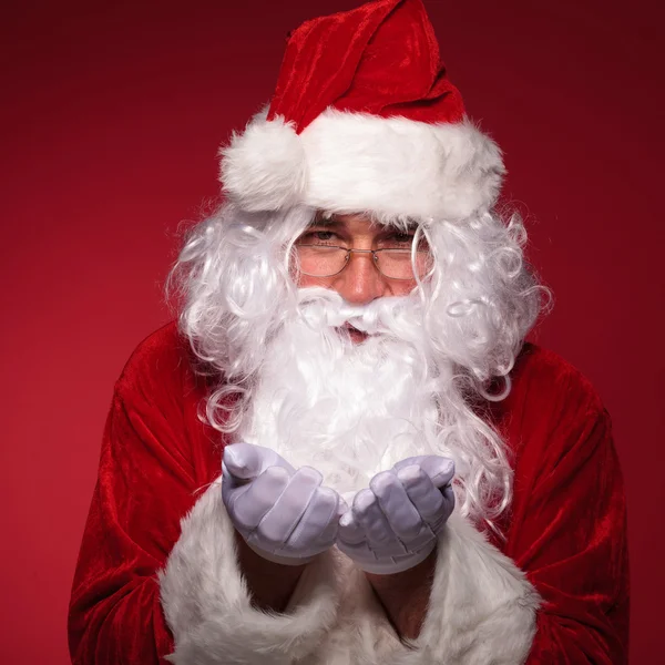 Papai Noel está segurando algo em suas mãos — Fotografia de Stock