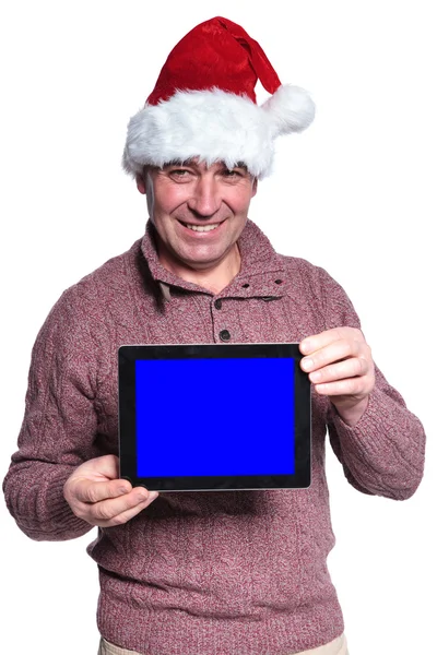 Mature casual man wearing santa hat is showing a pad — Stock Photo, Image