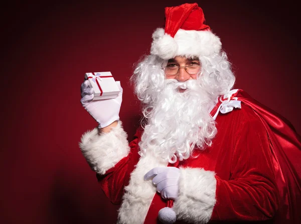 Side view of santa claus holding a small present box — Stock Photo, Image