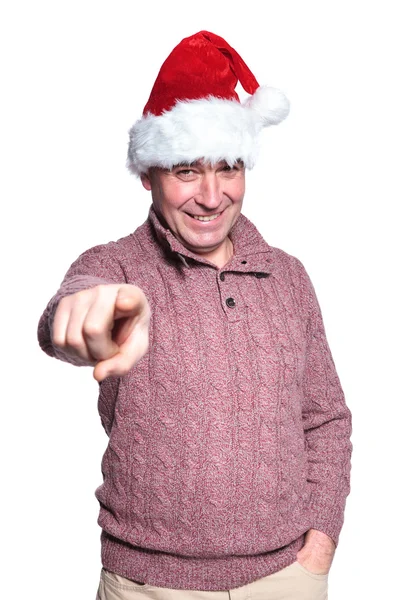 Dojrzały człowiek dorywczo w santa hat jest wskazywanie palcem — Zdjęcie stockowe