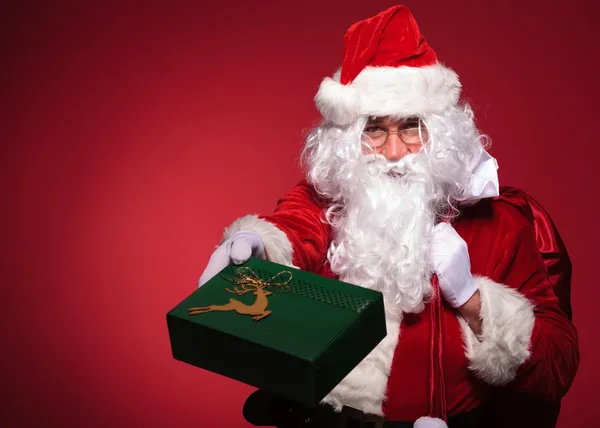 Santa claus is giving you a green present box — Stock Photo, Image