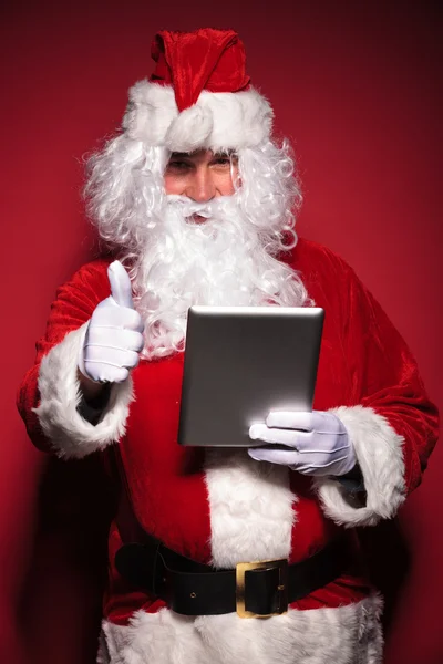 Santa Claus liest auf seinem Tablet-Pad über gute Nachrichten — Stockfoto