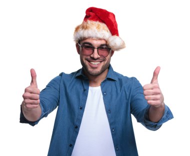 ok işareti yaparak santa şapka genç adam