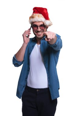 adam telefonda konuşurken ve işaret Noel Baba şapkası