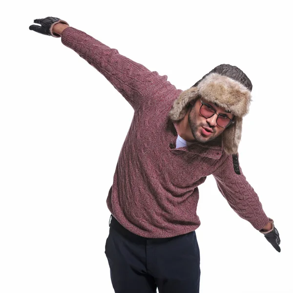 Man in winter clothes is impersonating an airplane — Stock Photo, Image