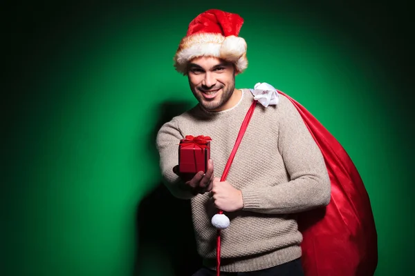 Papai Noel está oferecendo-lhe uma pequena caixa de presente — Fotografia de Stock