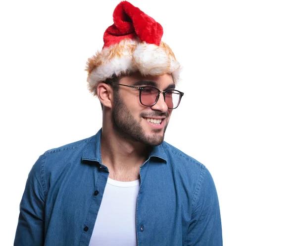 Seitenlächelnder Mann mit Weihnachtsmütze, der wegschaut — Stockfoto