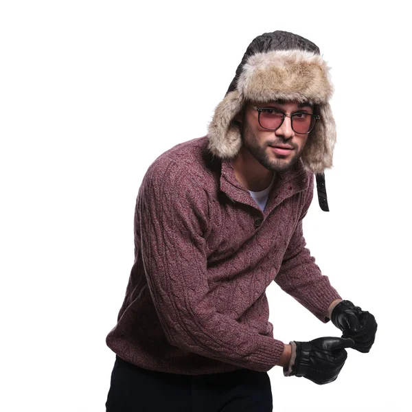 Młody człowiek w zimowe ubrania i futro kapelusz jest taniec — Zdjęcie stockowe
