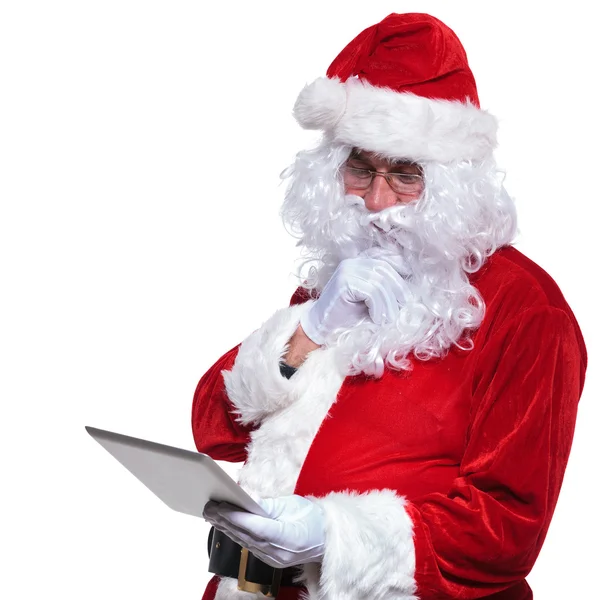 Вдумливий Санта Клаус читає бажання на планшеті — стокове фото