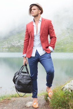 bir gölün önünde duran genç turizm
